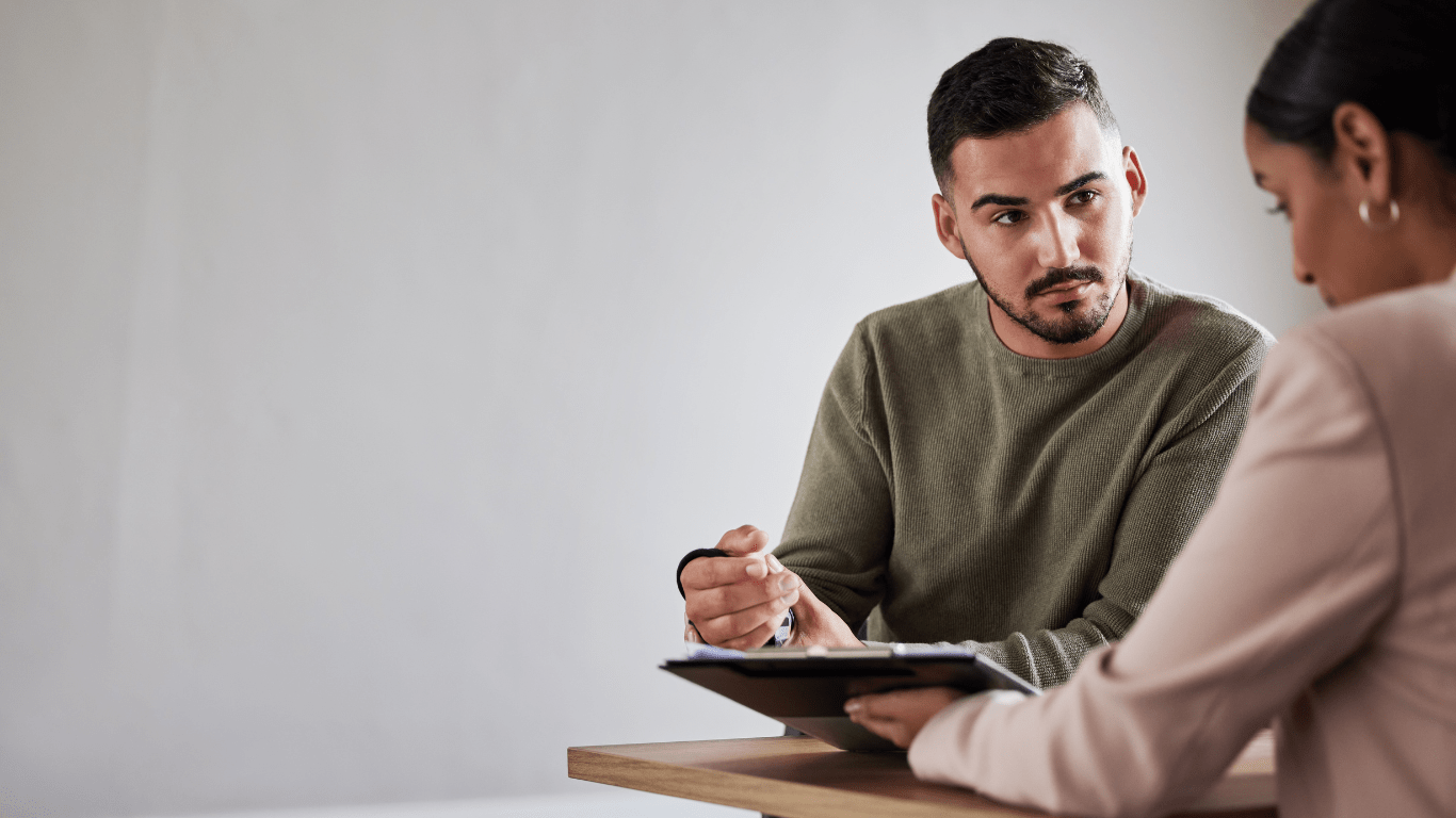 Two people sitting at a table talking to each other