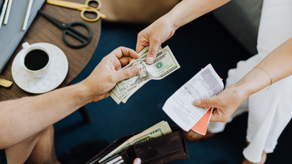 a person handing money to another person at a desk