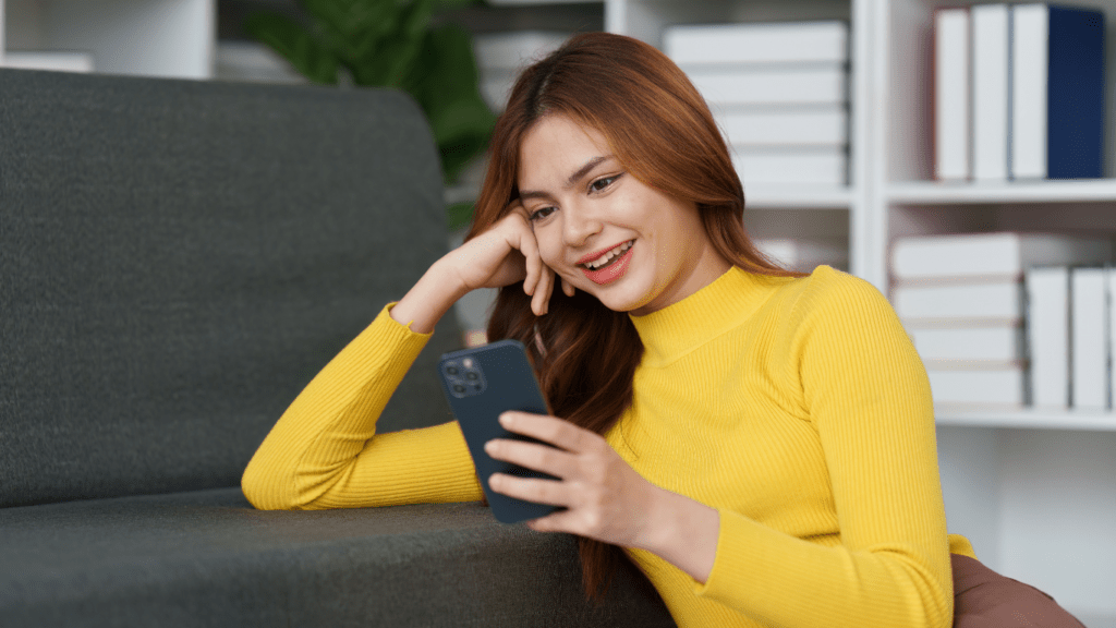 a person smiling on front of mobile phone